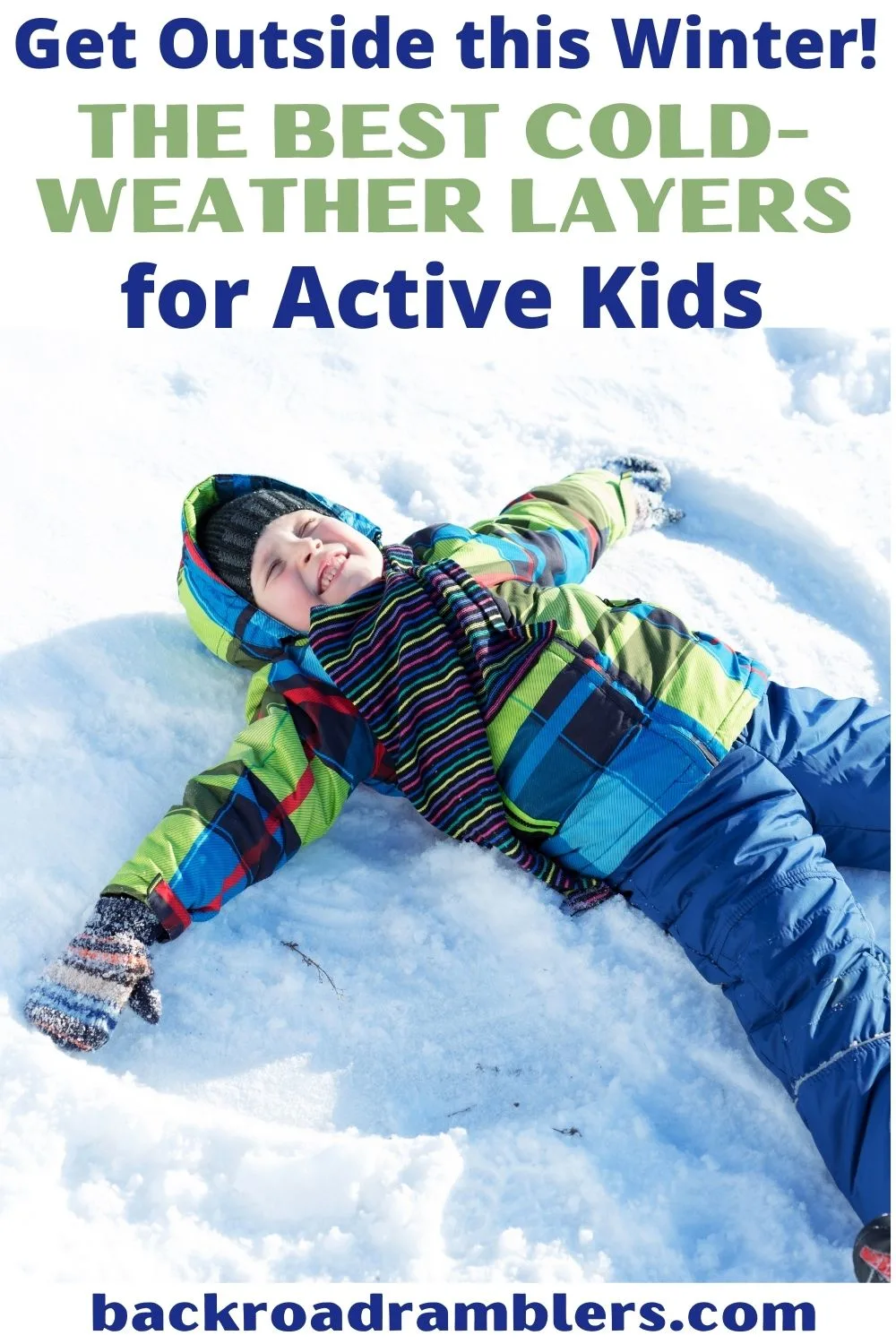 A boy makes a snow angel wearing winter clothes. Text overlay: Get outside this winter. The best cold weather layers for active kids.
