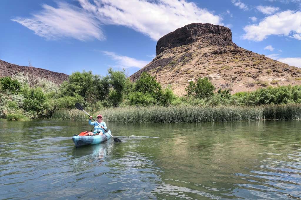 A woman paddles a kayak on the Snake River in Idaho. 