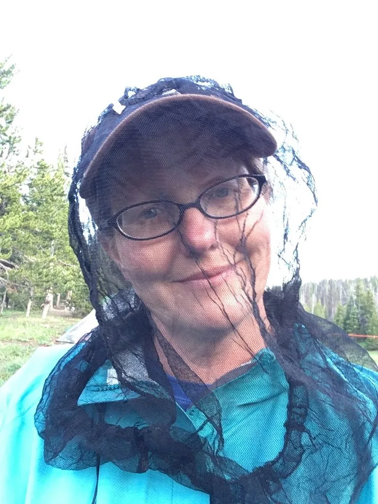 Wearing a bug net while camping.