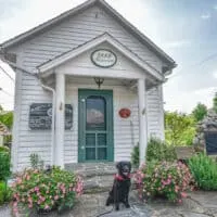 Flynn the black lab sits in front of a museum in dog-friendly Blowing Rock.
