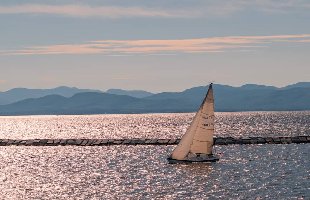 A sailboat on Lake Champlain in Burlington at sunset.