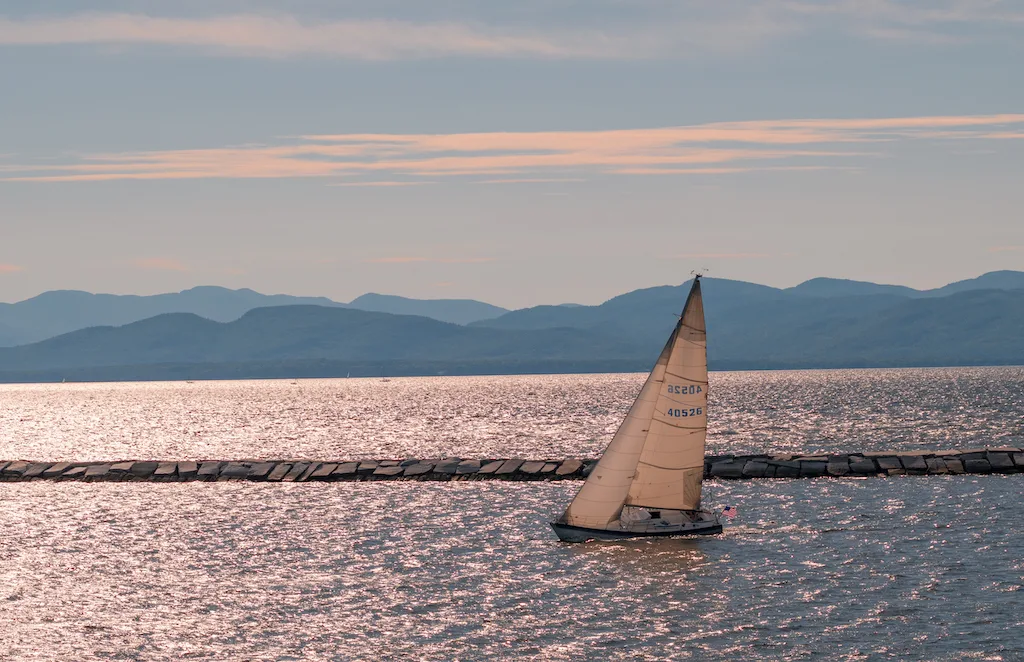 A sailboat on Lake Champlain in Burlington at sunset.