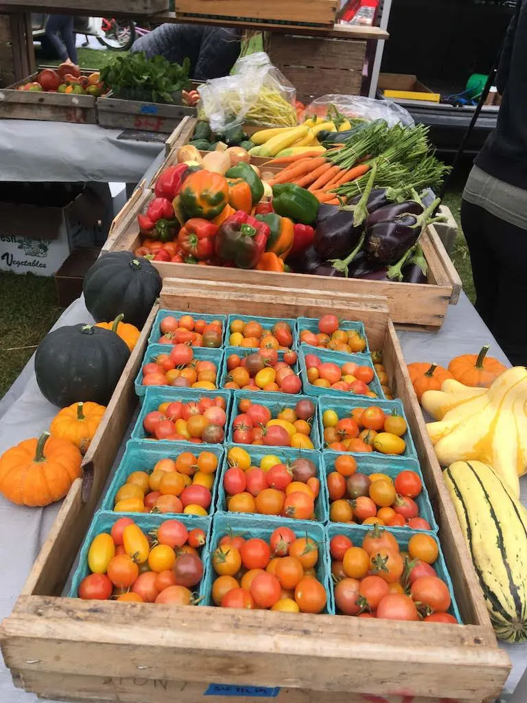 a table full of fresh vegetables at the Burlington Farmers' Market in Vermont.