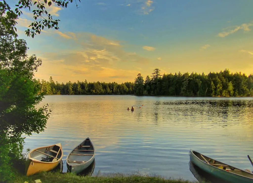 Three canoes near the shore on a lake in the Adirondacks.