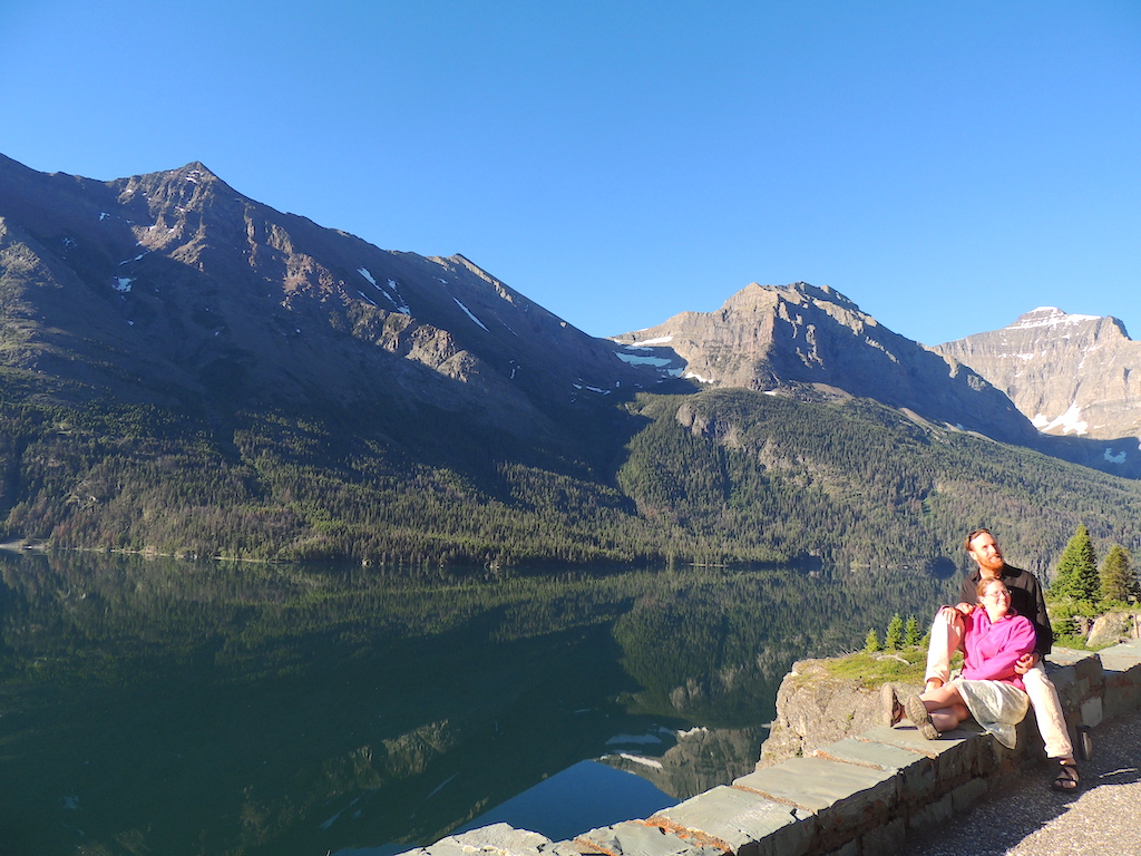 Tara and Eric posing in front of mountains in Glacier National Park.