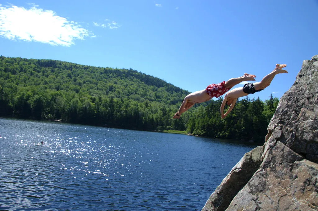 Two kids dive into Little Rock Pond in Vermont.