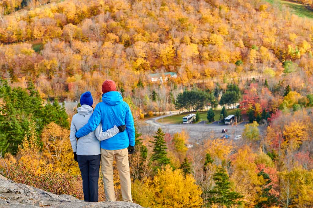 A couple stands on Artists Bluff in the fall. 