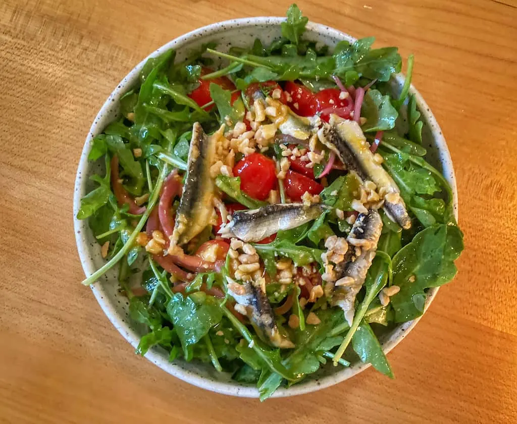 Arugula Salad with Boquerone, sungold vinaigrette, marcona almonds.