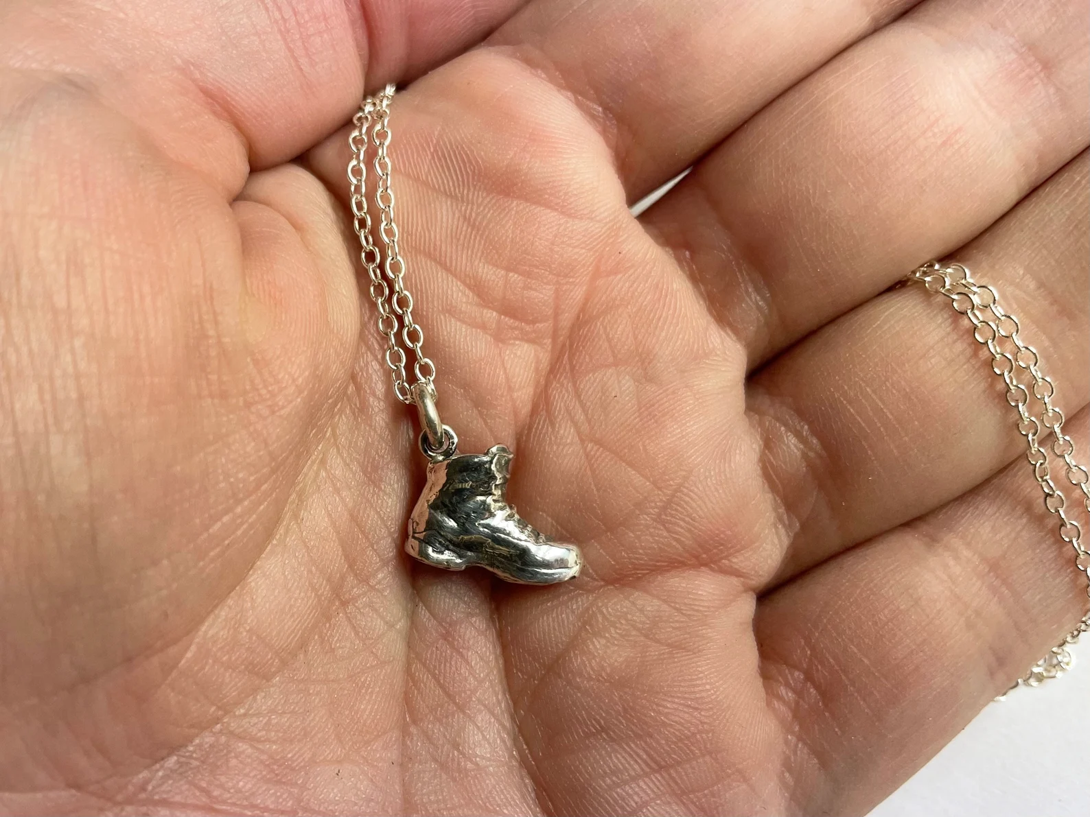 a beautiful sterling silver hiking boot pendant. 