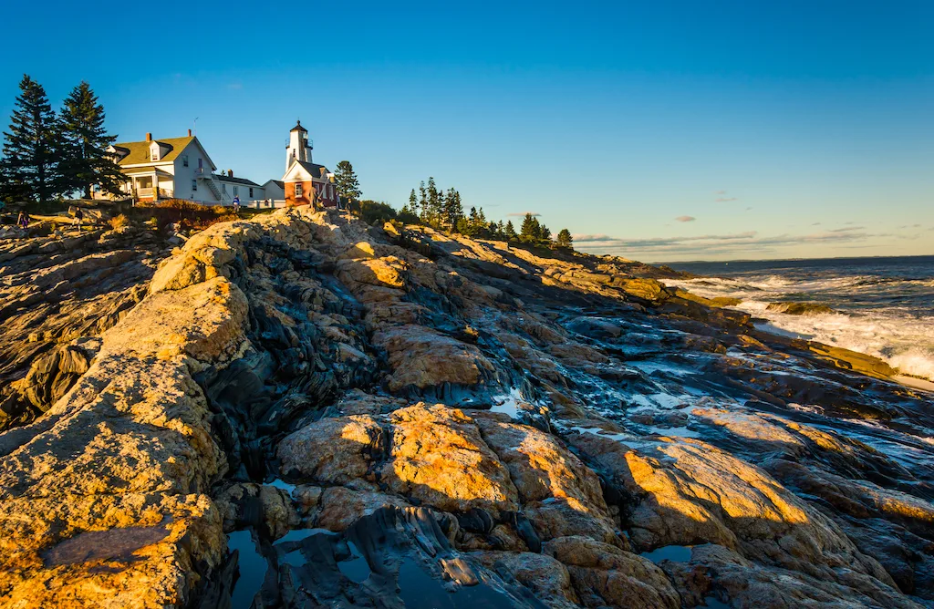 Evening light on rocks and Pemaquid Point Lighthouse, Maine.