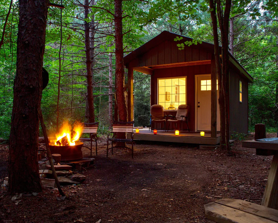 a tiny cabin with a fire in the fire pit