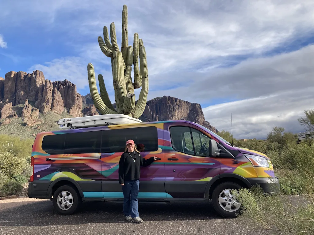 Tara standing in front of her van rental from Escape Campervans in Lost Dutchman State Park. 