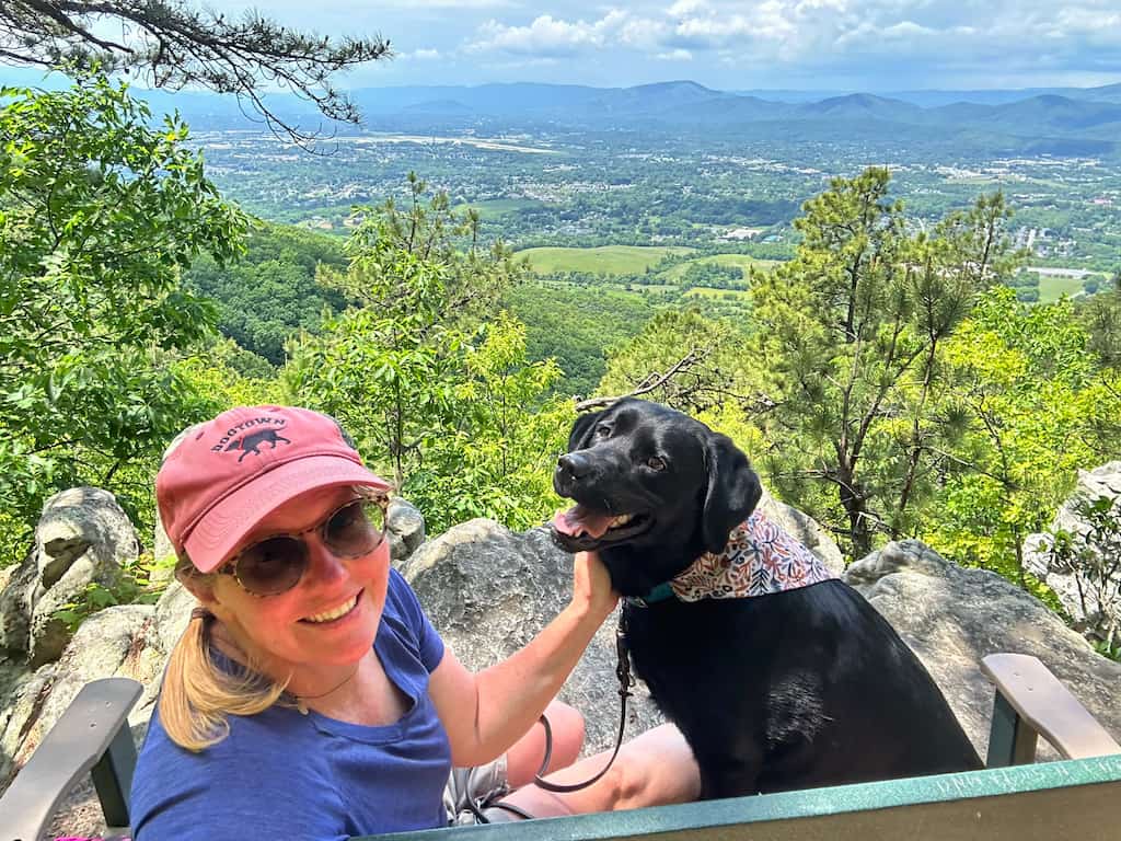 Tara and Malinda sit on a green bench looking out at the view of the Blue Ridge Mountains near Roanoke.