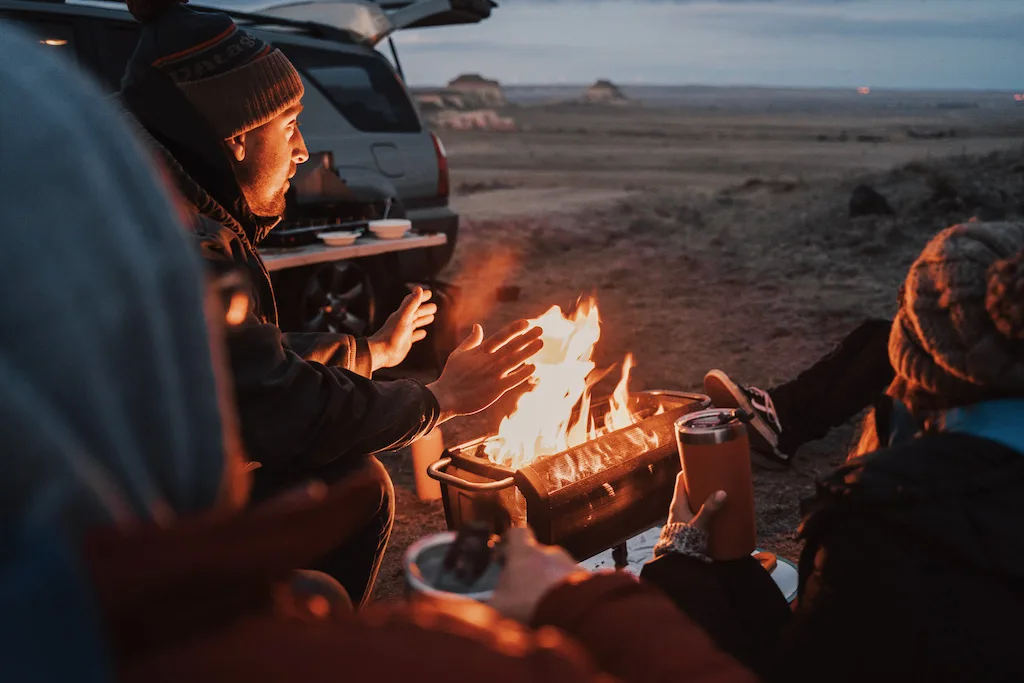 Two people enjoying a campfire on a portable fire pit. 
