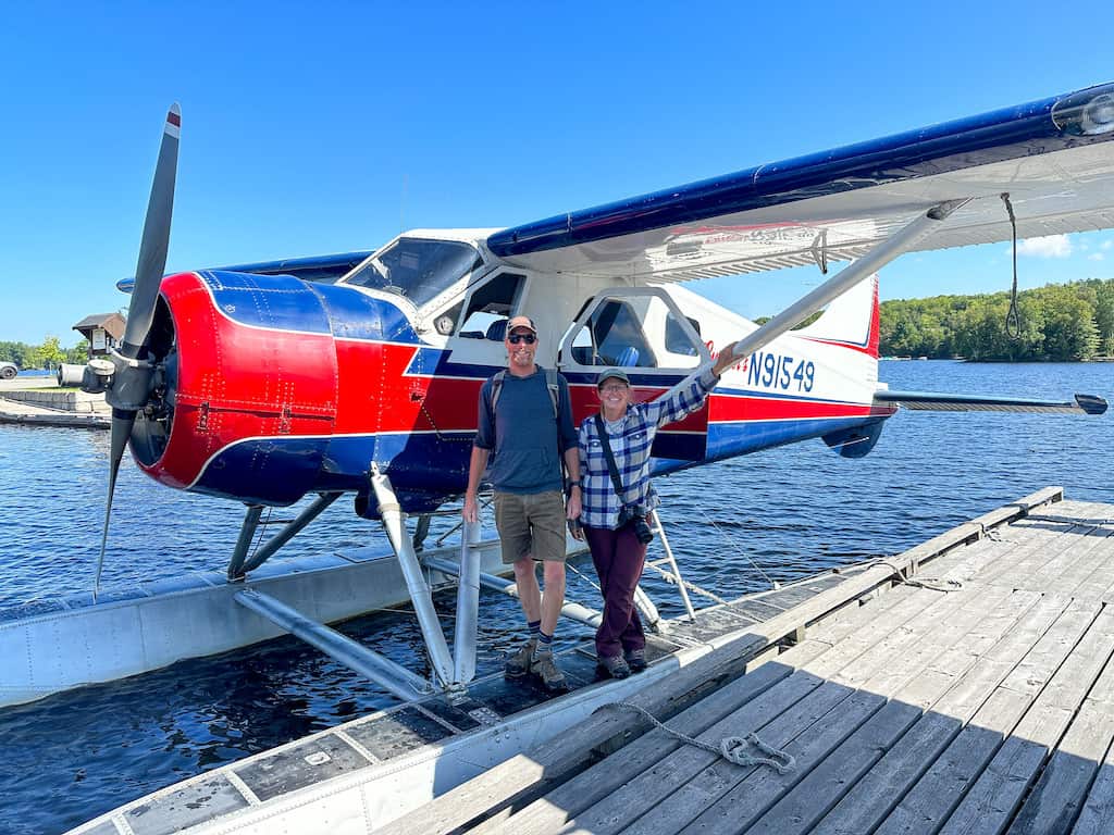 Tara and Eric posing next to a Cesna seaplane.