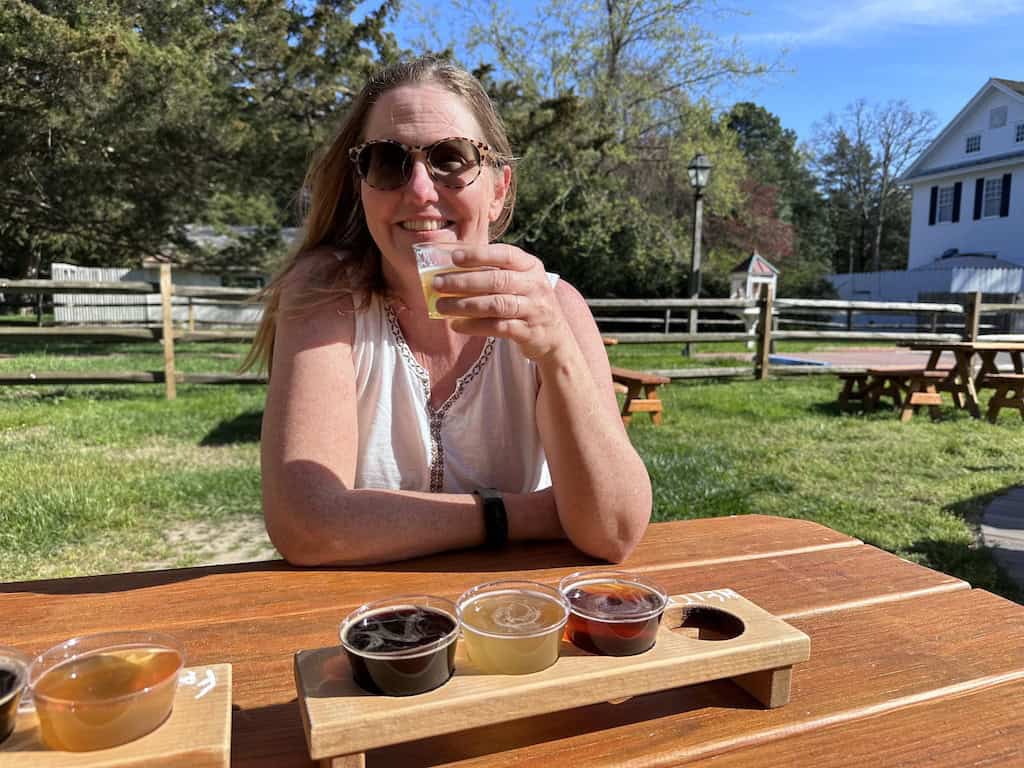 Tara sitting at a picnic table enjoying a flight of beers at Cold Spring Brewery in Cape May, New Jersey.